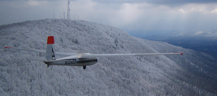 L-13 two-place glider ridge soaring over a snow-covered ridgeline.